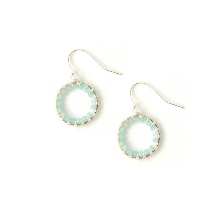 A pair of silver-toned drop earrings featuring open circular hoops bordered with small light blue-green beads, suspended from silver-toned fishhook wires on a plain white background.
